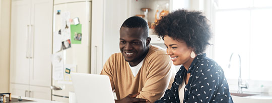 African American couple looking at their online account on their laptop