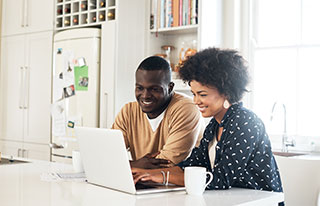 African American couple looking at their online account on their laptop